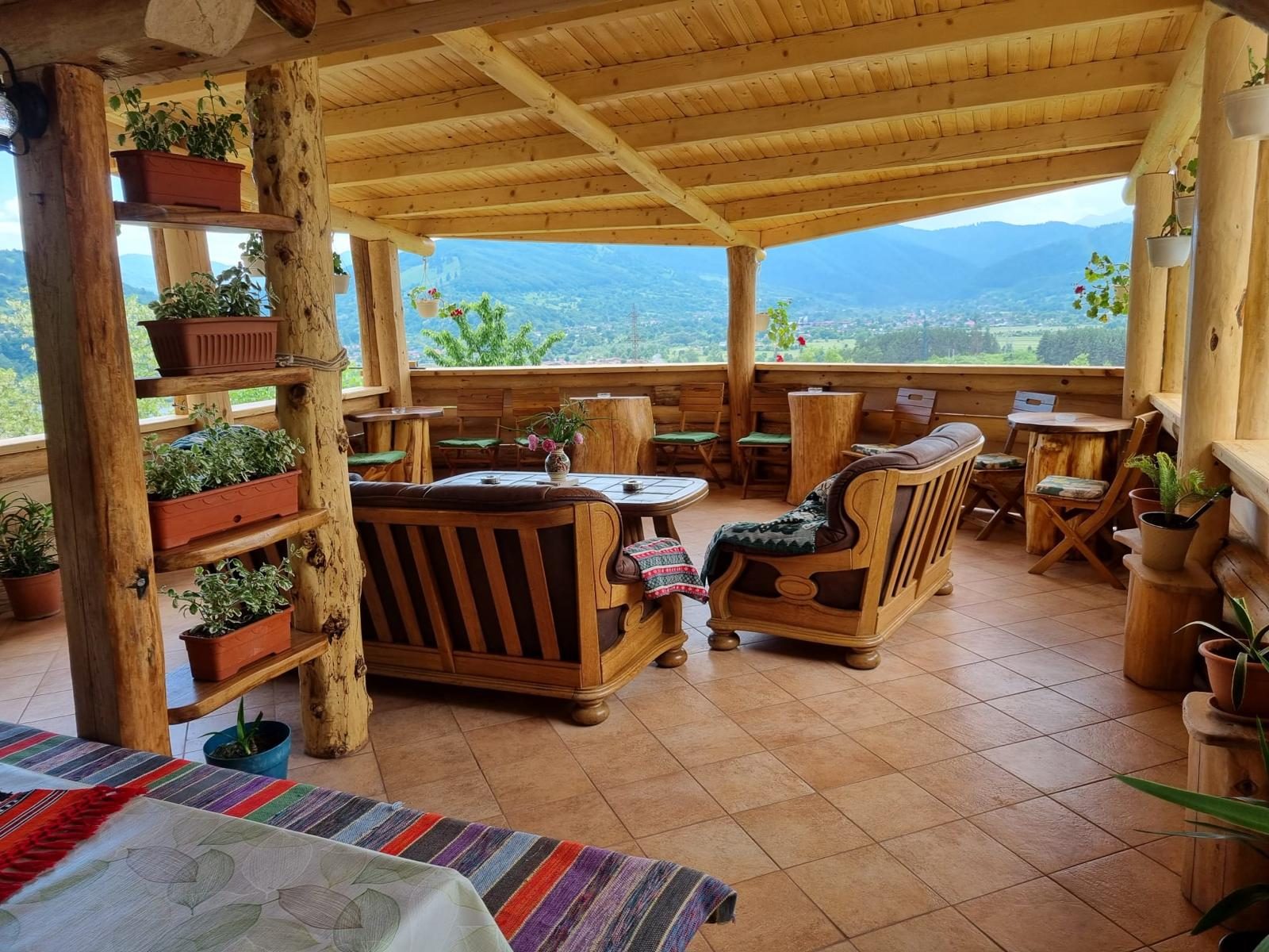 Open timber lounge at Vila Victoria with panoramic views over the Neamt mountains